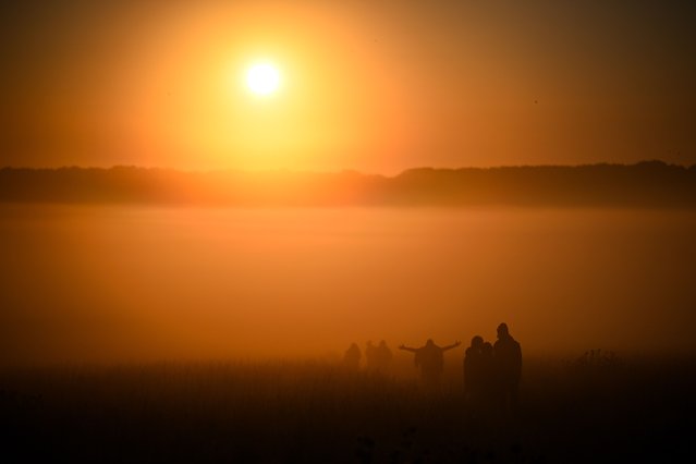 Visitors walk towards the sunrise at Stonehenge, on June 21, 2024 in Wiltshire, England. On the longest day of the year in the Northern Hemisphere, the sun rises in perfect alignment with the Heel Stone and Altar Stone of Stonehenge's 5000-year-old circle. This alignment shows the ancient builders' understanding of the solar calendar and suggests Stonehenge may have served as a calendar or temple for important dates and events - a tradition that continues to be marked each year. (Photo by Finnbarr Webster/Getty Images)