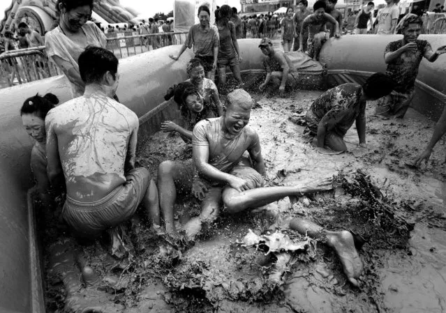 Participants play in a mud pool during the Boryeong Mud Festival. (Photo by Ahn Young-joon/Associated Press)