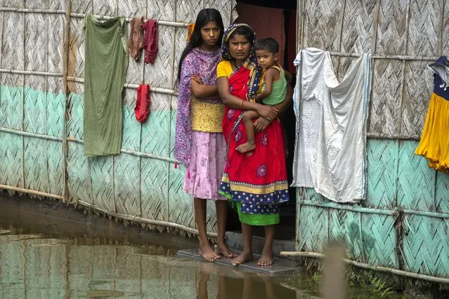 A flood affected family waits for the help at marooned Tarabari village, west of Gauhati, in the northeastern Indian state of Assam, Monday, June 20, 2022. (Photo by Anupam Nath/AP Photo)
