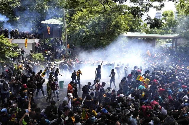 Police use tear gas to disperse the protesters who stormed the compound of prime minister Ranil Wickremesinghe 's office, demanding he resign after president Gotabaya Rajapaksa fled the country amid economic crisis in Colombo, Sri Lanka, Wednesday, July 13, 2022. Sri Lanka’s president fled the country early Wednesday, slipping away only hours before he promised to resign under pressure from protesters enraged by a devastating economic crisis. But the crowds quickly trained their ire on the prime minister, storming his office and demanding he also go. (Photo by Eranga Jayawardena/AP Photo)