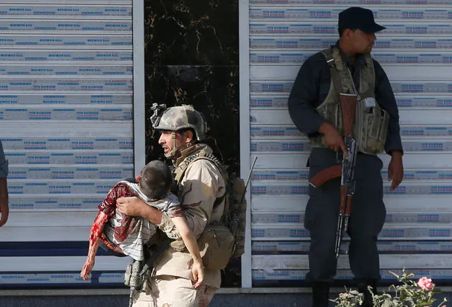 A member of Afghan special force carries an injured boy after a suicide attack followed by a clash between Afghan forces and insurgents, attack on a Shi'ite Muslim mosque in Kabul, Afghanistan on Friday, August 25, 2017. (Photo by Omar Sobhani/Reuters)