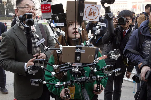In this file photo taken Friday, March 3, 2017, a Chinese journalist operates a harness with multiple recording devices capable of recording and multiple live streamings outside the Great Hall of the People where the opening session of the Chinese People's Political Consultative Conference (CPPCC) was held in Beijing, China. China on Tuesday, March 3, 2020 denounced a move by the Trump administration to cap the number of Chinese state-run media journalists who can work in the United States as “based on the Cold War mentality and ideological prejudice”. (Photo by Ng Han Guan/AP Photo/File)