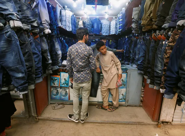 Afghan youths shop for their clothes while preparing for the Eid al-Fitr in Kabul, Afghanistan July 4, 2016. (Photo by Omar Sobhani/Reuters)