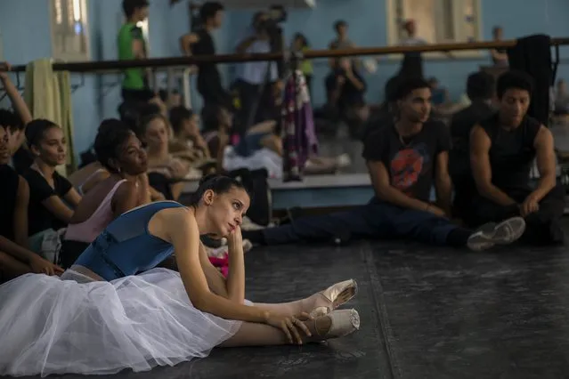 Members of the national ballet of Cuba stretch while they watch a rehearsal directed by Viengsay Valdes in Havana, Cuba, Thursday, December 12, 2019. Valdes, the new head of Cuba's legendary National Ballet, says she hopes to renew the institution after the death of long-time director Alicia Alonso by introducing new choreography and appearances by dancers who have emigrated to other companies. (Photo by Ramon Espinosa/AP Photo)