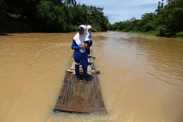 Students cross Ciherang river on a bamboo raft on their way home from school in Cilangkap village, Lebak Regency in Banten province, November 19, 2013, file photo. The raft has been used since January 2013 when the bridge broke due to flooding, local media reported. (Photo by Beawiharta Beawiharta/Reuters)