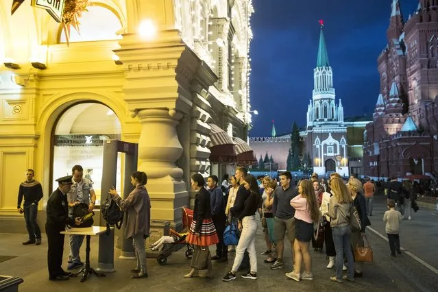In this Wednesday, September 13, 2017 file photo, people are checked by security guards before entering GUM, State Shop, at Red square in Moscow, Russia. Moscow is grappling with a slew of fake bomb calls that have prompted the evacuation of shopping malls, schools, railway stations and administrative buildings. The Tass news agency says there were over 100 anonymous bomb warnings in Moscow on Friday, October 6, 2017. No explosives have been found. (Photo by Pavel Golovkin/AP Photo)