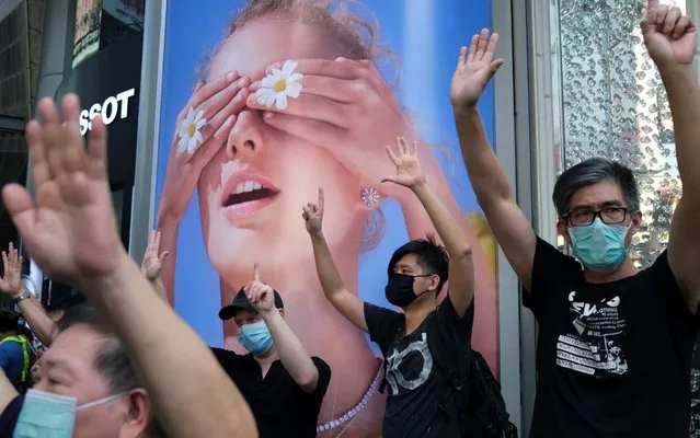 Anti-government protesters wearing face masks to avoid the spread of the coronavirus disease (COVID-19) raise their hands up symbolising of the “Five demands, not one less” during a protest, in Hong Kong, China on May 1, 2020. (Photo by Tyrone Siu/Reuters)