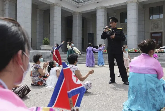People enjoy a performance in the plaza of Pyongyang Grand Theatre in Pyongyang, North Korea, Wednesday, July 27, 2022, on the occasion of the 69th anniversary of the end of the Korean War. The country celebrates the anniversary of the war's end as the day of “victory in the fatherland liberation war”. (Photo by Cha Song Ho/AP Photo)