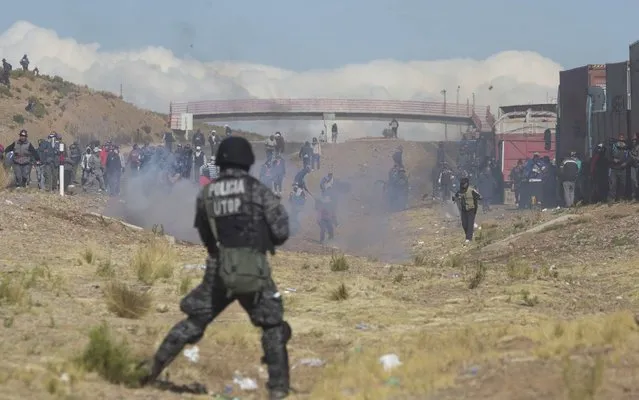 Independent miners clash with the police as they run from clouds of tear gas during protests in Panduro, Bolivia, Thursday, August 25, 2016. Government officials said that the striking miners kidnapped and beat to death the country’s deputy interior minister after he traveled to the area to mediate in the bitter conflict over mining laws. Government Minister Carlos Romero called it a “cowardly and brutal killing” and asked that the miners turn over the body of his deputy, Rodolfo Illanes. (Photo by Juan Karita/AP Photo)