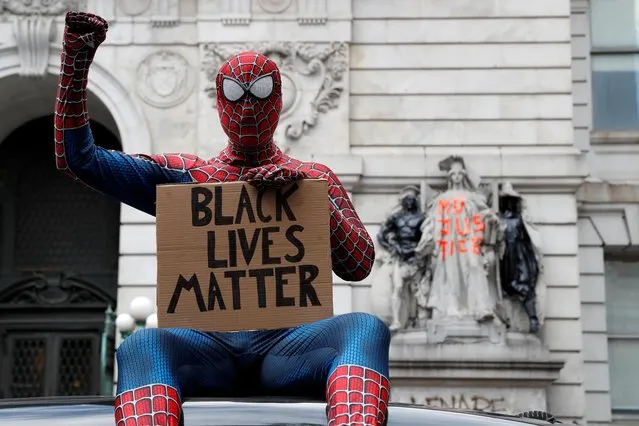 A person dressed as Spider-Man sits on a car near an area being called the “City Hall Autonomous Zone” that has been established to protest the New York Police Department and in support of “Black Lives Matter” near City Hall in lower Manhattan, in New York City, U.S., June 30, 2020. (Photo by Andrew Kelly/Reuters)