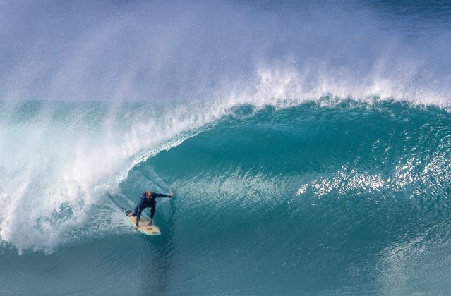 US surfer Mikey Redd rides a huge swell in training for the Da Hui Backdoor Shootout 2025 event held annually at Pipeline on the North Shore of Oahu, Hawaii, on December 26, 2024. The “Da Hui Backdoor Shootout” in 2025 is an invitation-only surfing competition held on the North Shore of Oahu, Hawaii, during a holding period from January 4 to 16, 2025. (Photo by Brian Bielmann/AFP Photo)