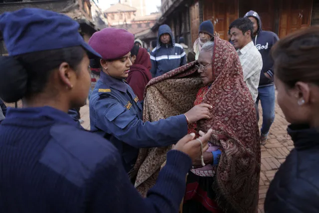 A Nepalese policewoman does security check to an elderly voter before entering polling station during the legislative elections in Thimi,Bhaktapur, Nepal, Thursday, December 7, 2017. Millions of people in Nepal are voting in the final phase of elections for members of the national and provincial assemblies. About 12 million voters in the southern half of the Himalayan nation are voting Thursday. (Photo by Niranjan Shrestha/AP Photo)