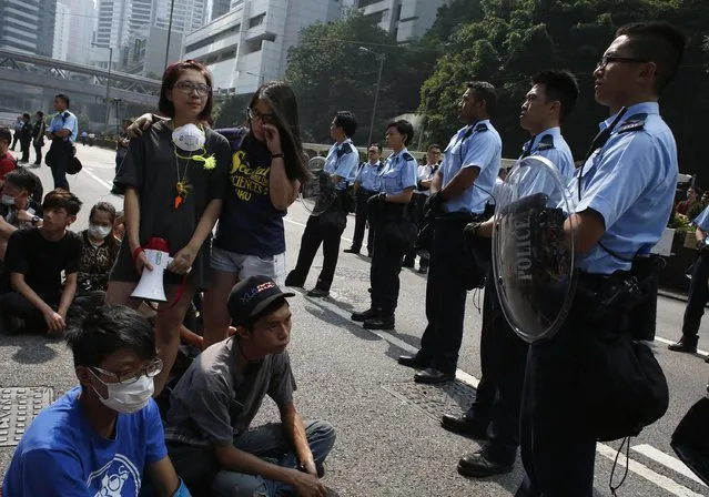 Student protesters show their emotions as they are surrounded by policemen on a main road leading to the financial Central district in Hong Kong October 14, 2014. Hong Kong police reopened one of the city's main thoroughfares to traffic on Tuesday after clearing barricades erected by democracy protesters who have occupied streets in the heart of the Chinese-ruled city for two weeks. (Photo by Bobby Yip/Reuters)