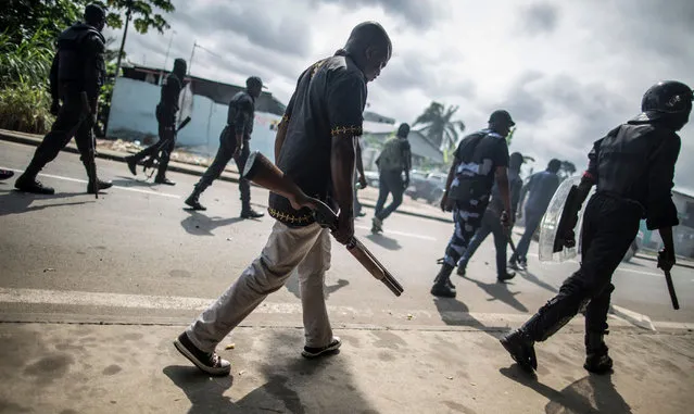 Gabonese police forces patrol as they clear barricades in the streets adjacent to the National Assembly, in Libreville, on September 1, 2016. The results of the presidential election, announced earlier on August 31, 2016 handed Ali Bongo a second term and extended his family's nearly five-decade-long rule. The opposition described the election as fraudulent and called for results from each of Gabon's polling stations to be made public to ensure the credibility of the overall outcome – a demand echoed by the United States and European Union. (Photo by Marco Longari/AFP Photo)