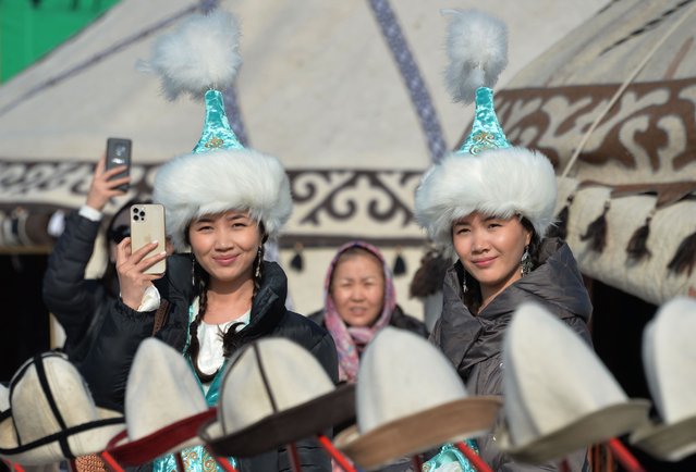 People wearing traditional costumes attend the celebrations marking the National Flag Day and the Day of Kyrgyz national “Ak-kalpak” hat at the central Ala-Too Square in Bishkek on March 4, 2021. (Photo by Vyacheslav Oseledko/AFP Photo)