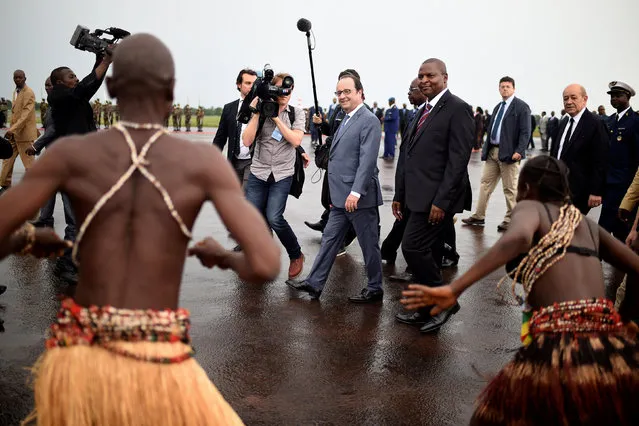 French President Francois Hollande (L) and French Defence minister Jean-Yves Le Drian (R) are welcomed by Central Africa's President Faustin Touadera (C) upon his arrival in Bangui, Central African Republic on May 13, 2016. (Photo by Stephane De Sakutin/Reuters)