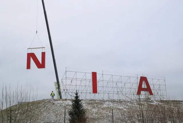 Workers dismantle the Nissan logo sign near the assembly plant, after the Japanese automaker completed the sale of its Russian legal entity to state-owned NAMI, in Saint Petersburg, Russia on November 25, 2022. (Photo by Igor Russak/Reuters)