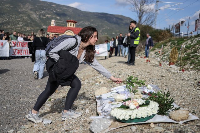 A person lays flowers at the site of Greece's deadliest train crash, as university students from across the country demonstrate at the site, in Tempi, Greece, on February 24, 2024. (Photo by Alexandros Avramidis/Reuters)