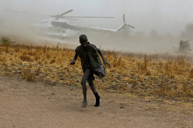 A boy moves away as a United Nations World Food Programme (WFP) helicopter lands in Rubkuai village, Unity State, northern South Sudan, February 18, 2017. (Photo by Siegfried Modola/Reuters)
