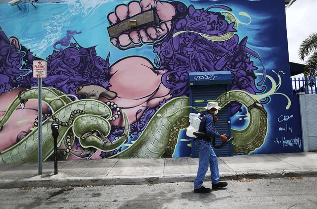 Larry Smart, a Miami-Dade County mosquito control inspector, uses a fogger to spray pesticide to kill mosquitos in the Wynwood neighborhood as the county fights to control the Zika virus outbreak on August 1, 2016 in Miami, Florida. (Photo by Joe Raedle/Getty Images)