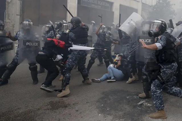 Riot policemen beat anti-government protesters during a protest near Parliament Square, in Beirut, Lebanon, Tuesday, September 1, 2020. On a visit to Lebanon, French President Emmanuel Macron issued a stern warning to Lebanon's political class Tuesday, urging them to commit to serious reforms within a few months or risk punitive action, including sanctions, if they fail to deliver. (Photo by Hassan Ammar/AP Photo)