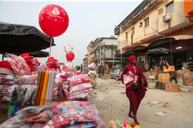 A woman walks by a roadside stall displaying Christmas and New Year's decorations in Abidjan, Ivory Coast, 19 December 2024. (Photo by Legnan Koula/EPA/EFE)