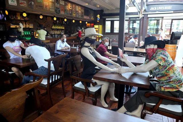 Mannequins are seen placed at tables to make customers sit according to social distancing rules at Elpaso Bar, which reopened after being closed for weeks, amid the spread of the coronavirus disease (COVID-19), in Ankara on June 24, 2020. Turkey, a nation of some 83 million, has removed most restrictions, reopened restaurants and resumed mass prayers but officials have warned against complacency. Turkey's daily infections have risen in recent weeks to over a thousand, and authorities have made face masks mandatory in public in several cities including Istanbul. (Photo by Adem Altan/AFP Photo)