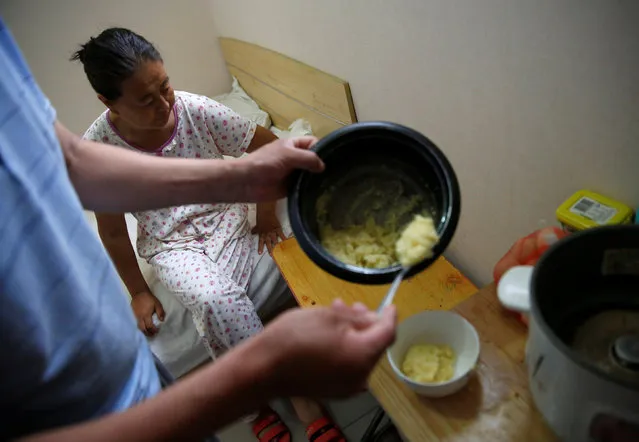 Liu serves breakfast for his wife, Wang, in their room at the accommodation where some patients and their family members stay while seeking medical treatments in Beijing, China, June 23, 2016. (Photo by Kim Kyung-Hoon/Reuters)