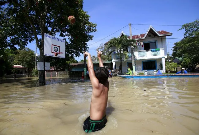A resident plays basketball while wading through floodwaters a week after typhoon Koppu battered Calumpit town, Bulacan province, north of Manila October 24, 2015. (Photo by Romeo Ranoco/Reuters)