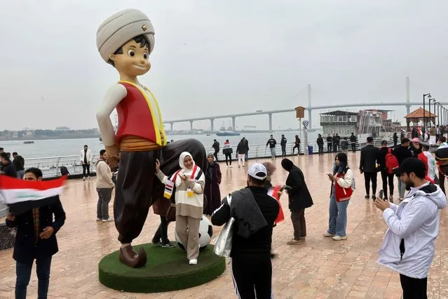 Tourists in Basra take memorial photos with the Sinbad the Sailor which is chosen as the 25th Gulf Cup's icon, in Basra, Iraq on January 9, 2023. (Photo by Thaier Al-Sudani/Reuters)