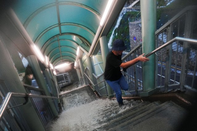 A pedestrian walks past a flooded stairs outside a hospital during heavy rains, in Hong Kong, China, on August 5, 2025. (Photo by Lam Yik/Reuters)