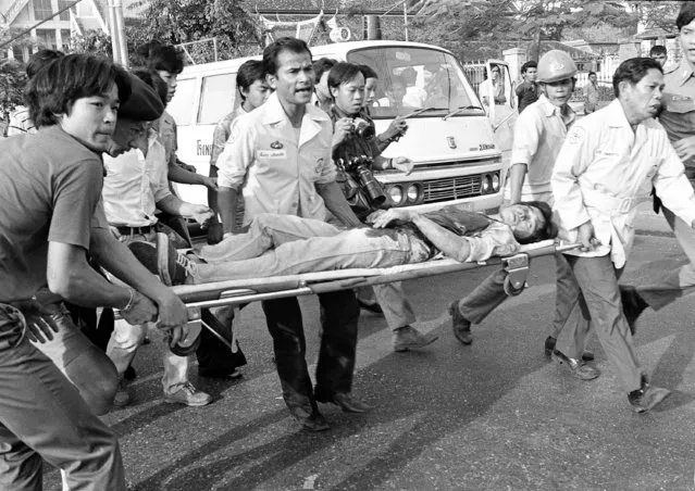 In this October 6, 1976 file photo a wounded student is taken to an ambulance after he was injured in the fighting at Thammasat University in Bangkok, Thailand. (Photo by Gary Mangkorn/AP Photo)