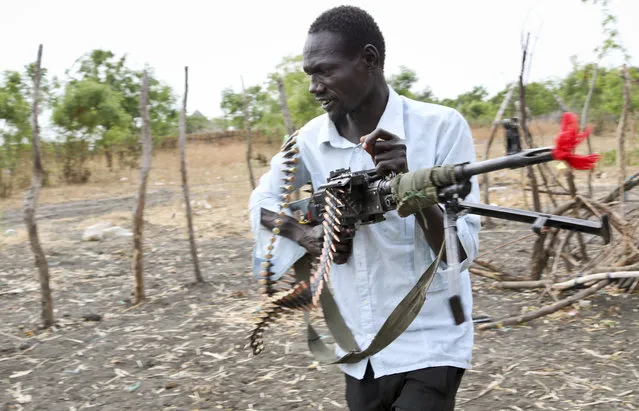 In this photo taken Sunday, January 21, 2018, an opposition fighter walks with his weapon on which is tied a red ribbon, signifying danger as a warning to government forces and a willingness to shed blood, according to an opposition spokesman, in Akobo town, one of the last rebel-held strongholds in South Sudan. (Photo by Sam Mednick/AP Photo)