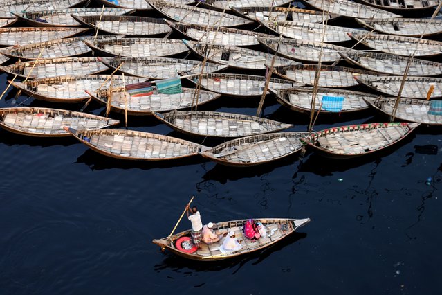 Amid the polluted, bluish waters of the Buriganga River at Sadarghat in Old Dhaka, boatmen navigate small wooden boats, ferrying passengers past hundreds of anchored boats on April 8, 2025. (Photo by Syed Mahabubul Kader/ZUMA Press Wire/Rex Features/Shutterstock)