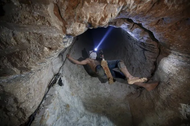 A Palestinian worker is lowered on a rope into a smuggling tunnel, that was flooded by Egyptian security forces, beneath the border between Egypt and southern Gaza Strip November 2, 2015. A network of Palestinian tunnels running under the frontier town of Rafah is now water-logged, destroyed by Cairo to sever what it says is a weapons smuggling route out of Gaza for Islamist insurgents in Egypt's Sinai desert. (Photo by Mohammed Salem/Reuters)