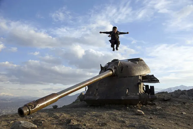 An Afghan boy jumps off the turret of a Soviet tank on a hilltop on the the outskirts of Kabul, Sunday, March, 4, 2018. (Photo by Rahmat Gul/AP Photo)