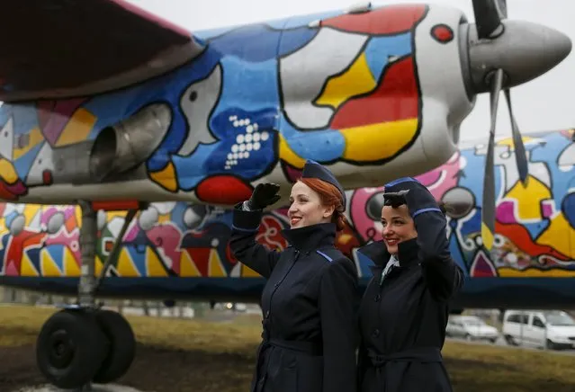 Stewardesses pose for picture in front of a painted Antonov-24 plane at Zhulyany airport in Kiev, Ukraine, November 5, 2015. The 45-year-old plane has been turned into an arts and exhibition space by the airport authorities with the help of Georgian artist Avtandil Gurgenidze. (Photo by Gleb Garanich/Reuters)