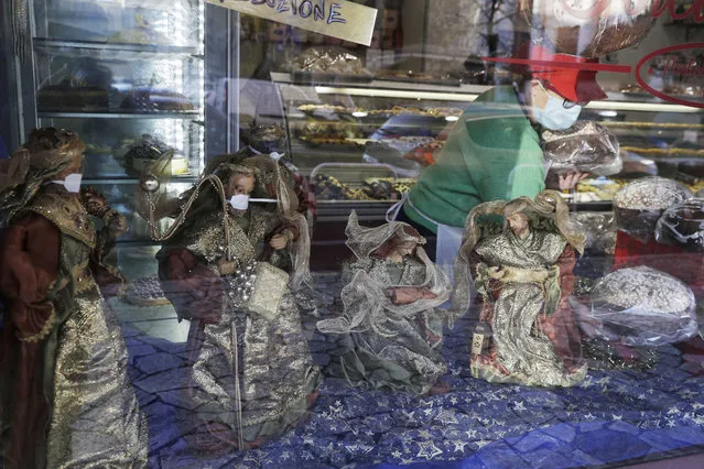 Statuettes of the Wise Kings wearing face masks adorn, along with the Nativity scene, the shop window of a pastry shop selling the traditional Italian Christmas cake, Panettone, in Rome, Wednesday, December 3, 2020. Italy is bracing for new restrictive measures during Christmas and New Year. Prime Minister Giuseppe Conte is expected to sign a new decree on Thursday following a cabinet meeting held on Wednesday night. The rules will likely prevent Italians from traveling across the country during this season holidays in an effort to avoid a new wave of contagion. (Photo by Gregorio Borgia/AP Photo)