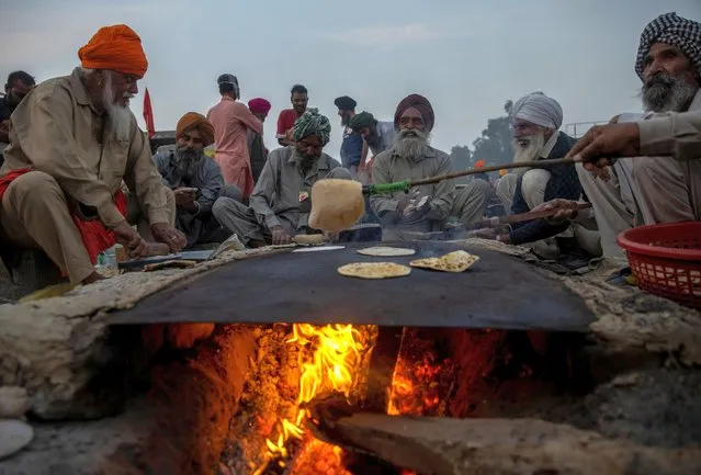 Farmers prepare roti (Indian bread) during a protest against the newly passed farm bills at Singhu border near Delhi, India, November 30, 2020. (Photo by Danish Siddiqui/Reuters)