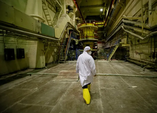 An employee walks through a pump room of the stopped third reactor at the Chernobyl nuclear power plant in Chernobyl, Ukraine April 20, 2018. (Photo by Gleb Garanich/Reuters)
