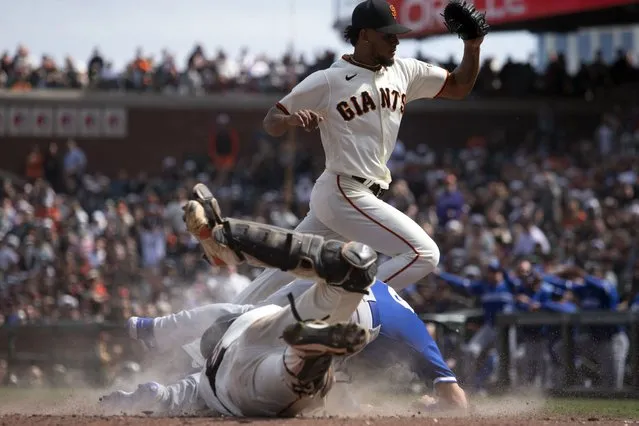 Kansas City Royals' pinch runner Nate Eaton, center, slides safely home between San Francisco Giants catcher Blake Sabol, bottom left, and pitcher Camilo Doval, top, on a wild pitch during the ninth inning of a baseball game, Saturday, April 8, 2023, in San Francisco. (Photo by D. Ross Cameron/AP Photo)