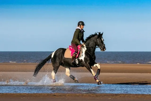 Emma rides her beloved 12 year old mare “Lily” along the golden shores of Southport beach in Merseyside, England on April 7, 2023. Warm Spring conditions with bright sunshine brought people out to this local beauty spot. (Photo by Cernan Elias/Alamy Live News)