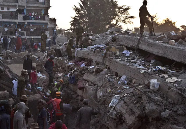 Rescue workers look for survivors at the site of the collapsed building in the capital Nairobi, Kenya , Monday, January 5, 2015. (Photo by Sayyid Azim/AP Photo)