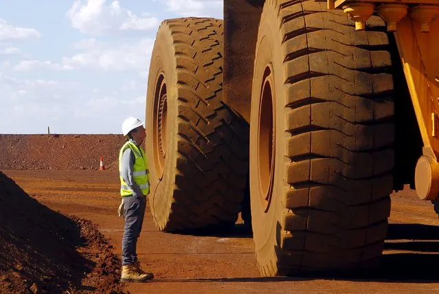 A worker checks a truck loaded with iron ore at the Fortescue Metals Group (FMG) Christmas Creek iron ore mine located south of Port Hedland in the Pilbara region of Western Australia, November 17, 2015. (Photo by Jim Regan/Reuters)
