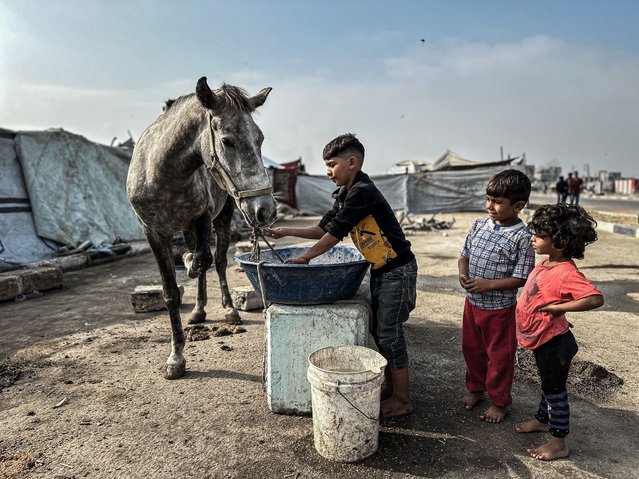 Palestinians whose homes were destroyed in Israeli attacks struggle to survive in makeshift tents built over the rubble along both sides of Salah al-Din Road in central Gaza, on November 10, 2025. Despite the lack of basic necessities, displaced residents endure harsh living conditions as they seek warmth and shelter amid the devastation left by the war. (Photo by Ramzi Abu Amer/APAImages/Rex Features/Shutterstock)