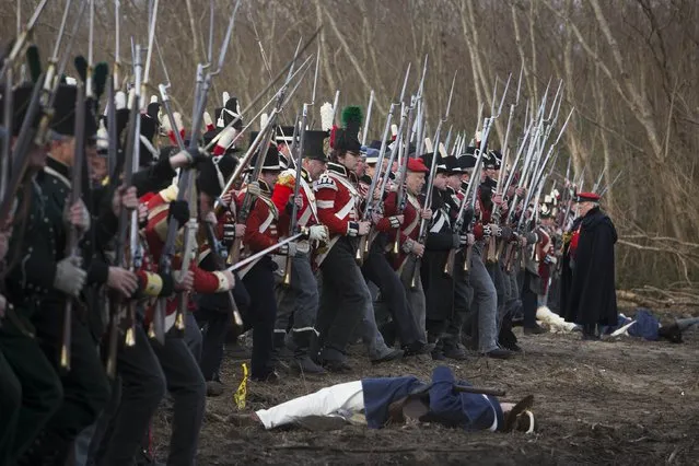 Reenactors playing the roll of British soldiers march towards United States fighters during a reenactment of the Battle of New Orleans in the War of 1812, marking its  bicentennial  in Chalmette, Louisiana January 10, 2015. (Photo by Lee Celano/Reuters)