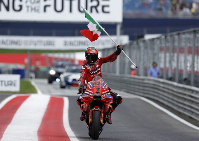 Ducati Lenovo Team's Italian rider Francesco Bagnaia celebrates with his national flag after winning the Austrian MotoGP race at the Red Bull Ring in Spielberg, Austria on August 18, 2024. (Photo by Erwin Scheriau/APA via AFP Photo)