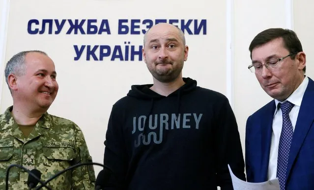 Russian journalist Arkady Babchenko, center, Vasily Gritsak, head of the Ukrainian Security Service, left, and Ukrainian Prosecutor General Yuriy Lutsenko attend a news conference at the Ukrainian Security Service on Wednesday, May 30, 2018. Babchenko turned up at a news conference in the Ukrainian capital Wednesday less than 24 hours after police reported he had been shot and killed at his Kiev apartment building. The country's security services said Babchenko's death was faked to foil a plot to take his life. (Photo by Valentyn Ogirenko/Reuters)