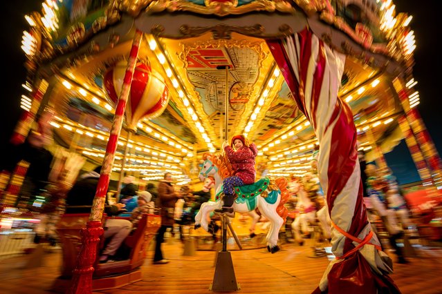 A child rides a merry-go-round at a Christmas fair in Bucharest, Romania, Wednesday, December 3, 2025. (Photo by Andreea Alexandru/AP Photo)