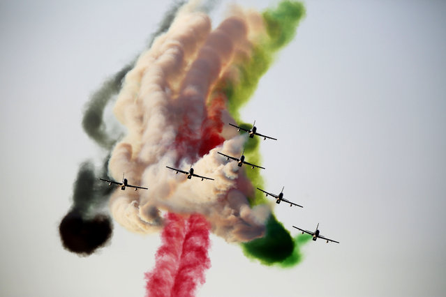 The Al Fursan aerobatic team of the United Arab Emirates' air force performs a stunt at the World Air Games in Dubai, United Arab Emirates, on Sunday, December 6, 2015. The World Air Games includes precision aerobatics, skydiving and hot air balloon competitions. (Photo by Jon Gambrell/AP Photo)